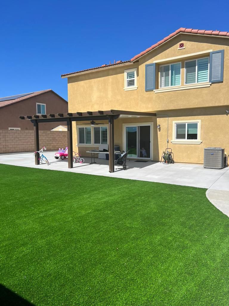 Two-Story Home With Turf Lawn and Pergola