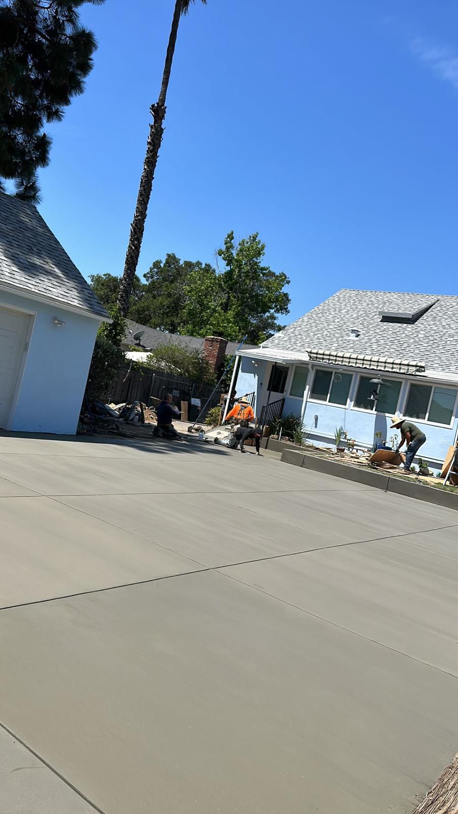 Wide Concrete Driveway With Workers Finishing